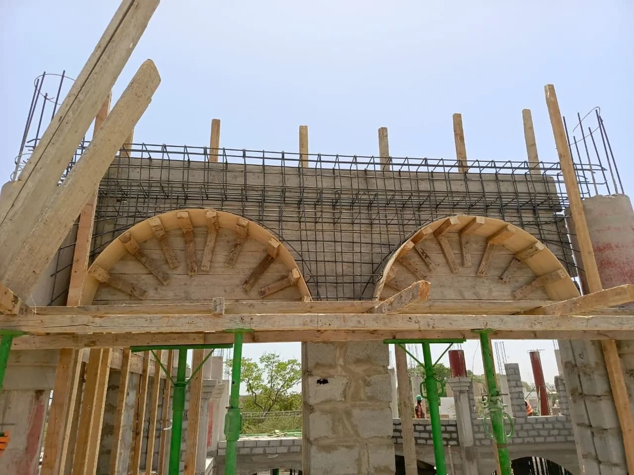 Coffrage bois de deux arcs surmontés d'un ferraillage, étais verts