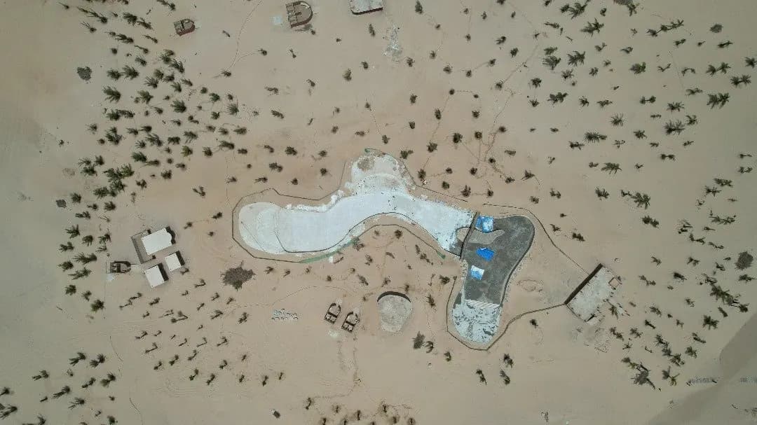Vue aérienne zénithale d'un bassin de forme libre au milieu des dunes