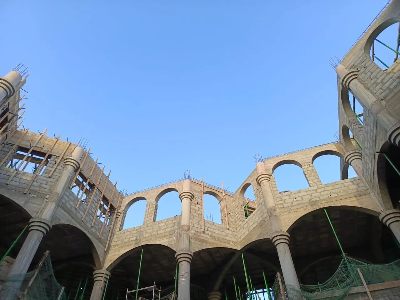 Arcades et colonnes en béton vues d'en bas, gros œuvre en cours