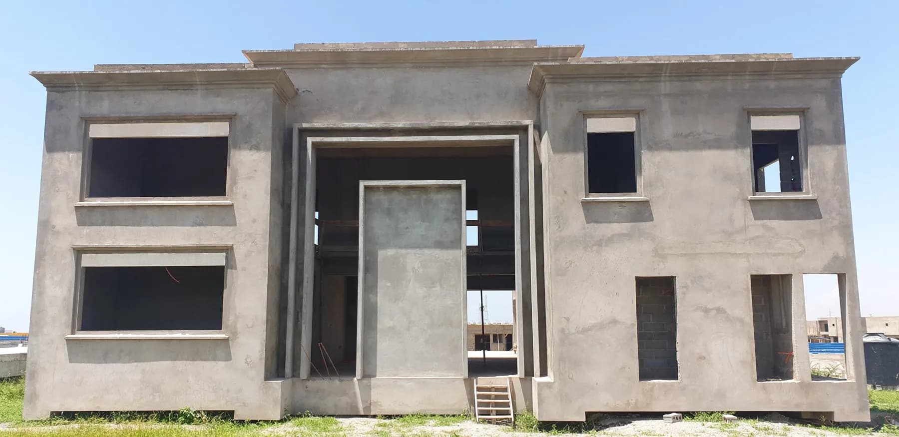 Façade en béton brut d'une grande villa à deux niveaux