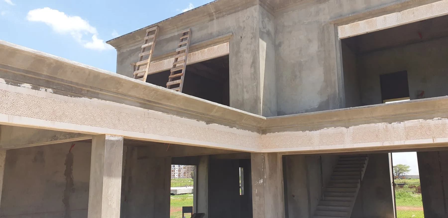 Structure béton d'une villa avec frise ornementale en plâtre sur les poutres