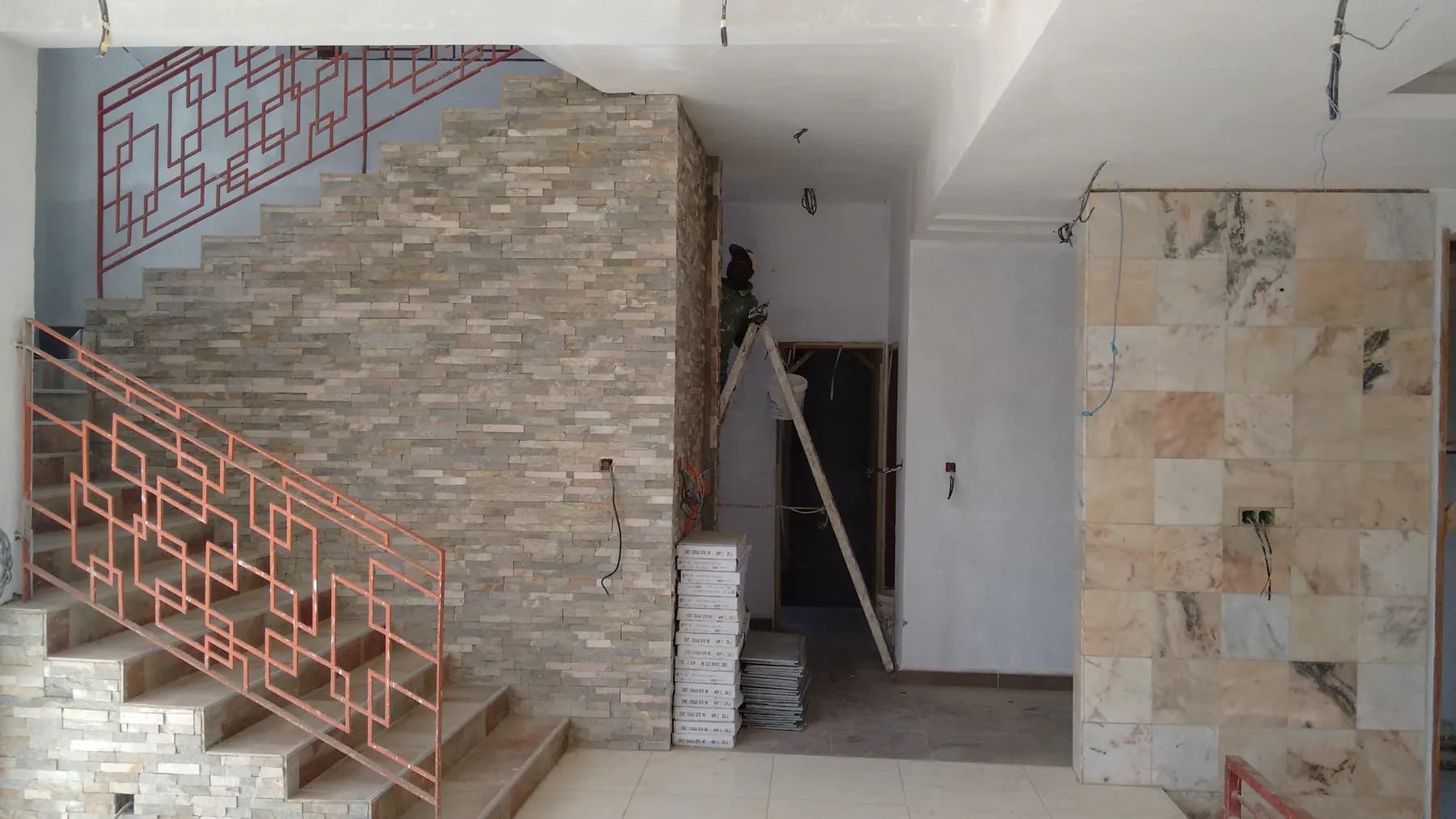 Escalier avec mur en parement pierre et garde-corps métallique géométrique